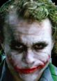 Heath Ledger as The Joker, showcasing a menacing expression with iconic makeup and green hair in a dark background.