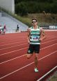 João Coelho sprinting on a track, showcasing athleticism and determination in competitive sportswear.