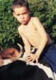 Young boy with a serious expression sitting on a cow, surrounded by greenery, representing rural life in Caiuá.