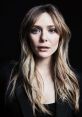 Portrait of Elizabeth Olsen with tousled hair and natural makeup, showcasing a captivating expression against a dark background.