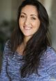 Portrait of Stephney Rose with a warm smile, featuring long dark hair and a stylish sweater, exuding confidence and charm.