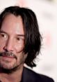 Close-up of Keanu Reeves showcasing his distinctive style and thoughtful expression at a public event.