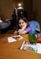 Young girl sitting at a table with pizza slice, enjoying family time in a cozy hotel room. Perfect for memorable moments.