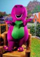 Barney the dinosaur smiles while posing on a wooden structure, surrounded by a colorful, friendly neighborhood setting.