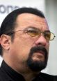 Close-up of Steven Seagal, showcasing his signature sunglasses and intense expression, reflecting his iconic action star persona.