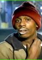 Tyrone Biggums, iconic Chappelle's Show character, wearing a red beanie and engaging humorously in a street scene.