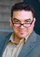 Daniel Escobar López, smiling confidently in a gray suit and glasses, showcasing his charismatic personality.