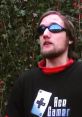 Person wearing sunglasses and an "Ace Gamer" shirt, outdoors, promoting gaming culture and Zeb 89.