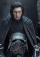 Kylo Ren stands solemnly, looking down at his cracked helmet, embodying the dark side's struggle in Star Wars.