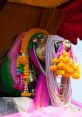 Golden statue adorned with vibrant flowers and colorful fabrics, representing Prayong Klunbida's cultural significance.