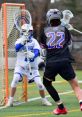 Lacrosse action shot featuring a player in black with the number 22 shooting on goal against a goalie in white.