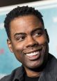 Chris Rock smiling at a premiere event, showcasing his charismatic personality and distinctive style.