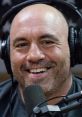 Joe Rogan smiling in headphones, engaging in a podcast discussion for Version 2.0, showcasing his charismatic personality.