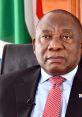 Cyril Ramaphosa in a formal setting, wearing a red tie with South African flags in the background, showcasing leadership.