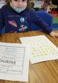 Child engaging in learning activity with alphabet worksheets and creative writing, showcasing educational development.