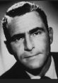 Black and white portrait of Ian Melvin, featuring a thoughtful expression and classic 1950s hairstyle in a suit.