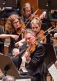 Violinist performing passionately in an orchestra, showcasing talent and artistry. Judson Griffin's captivating performance.