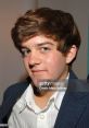 Young man with stylish hair and a suit, showcasing a calm expression, representing Emerson Mattia's public persona.