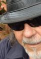 Close-up of a man with glasses and a black hat, embodying the cool vibe of Blue Lew Hogue.