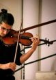 Violinist performing passionately, showcasing skill in a vibrant setting, highlighting TangoSaenz's musical excellence.