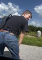 Smiling young man in casual attire poses playfully outdoors, showcasing a fun, carefree moment against a sunny backdrop.