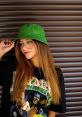 Giovanna Nieto Canto styles a green bucket hat and graphic tee, showcasing a trendy, casual look on a sunny day.