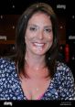 Smiling woman with dark hair in floral blouse, showcasing warmth and charm, ideal for biography or event features.