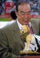 Angel Fernandez smiling while holding a lion statue, celebrating a significant achievement in sports.