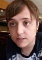 Young man with short brown hair, engaged in conversation, possibly in a café setting, related to Chernoandyl nig.