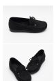 Black suede moccasin slippers featuring a soft interior and decorative lace. Ideal for comfort and casual style.