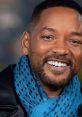 Will Smith smiles brightly, showcasing his stylish blue scarf and confident demeanor, embodying his charismatic presence.