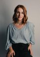 Alyssa Park with a warm smile, wearing a striped top, seated against a neutral background, radiating confidence and style.