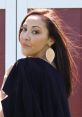 Portrait of Melissa Garcia showcasing elegant styling with long hair, oversized earrings, and a confident expression outdoors.