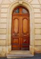 Elegant wooden double doors with intricate carvings and a classic arch, showcasing timeless architectural design.