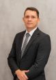 Professional portrait of Laurentino Adriel in a suit, exuding confidence and sophistication against a neutral background.