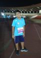 Kavyansh Bedi at a night marathon event, wearing a bib number 149-F, ready to run on the track.