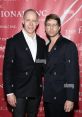 Gabe Von Ranson and companion pose at a formal event, showcasing stylish attire and a vibrant background.