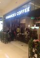 Starbucks store interior with customers enjoying coffee and pastries in a cozy atmosphere, ideal for a relaxing break.