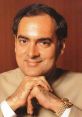 Close-up portrait of Rajiv Gandhi, former Prime Minister of India, smiling with hands clasped, wearing a traditional outfit.