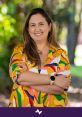 Natalia Niño smiling outdoors, wearing a colorful shirt, showcasing a vibrant personality and positive energy in a natural setting.