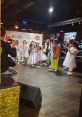 Children performing in white outfits at an event, with a spotlight on entertainment and celebration. Роман Степанов involved.