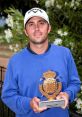 Miguel Angel Duque celebrates his victory, holding a trophy from the X Circuito de Madrid de Profesionales golf tournament.