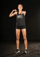 Natalia Ruiz showcasing athleticism in a UNLV tank top and shorts, exuding confidence and strength on a dark backdrop.