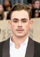 Young man with stylish hair and mustache, wearing a formal outfit at a red carpet event. Perfect for BIGODE fashion inspiration.