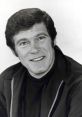 Classic portrait of Christopher G, showcasing his charming smile and 70s style in a black jacket. Vintage black and white.