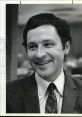 Smiling man in a suit with a paisley tie, representing a professional atmosphere, suitable for historical contexts.