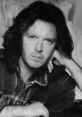 Portrait of a man with long hair in a denim jacket, exuding a contemplative and confident vibe. Ideal for Tozzi fans.