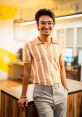 Vatsal Pandya smiling confidently in a stylish striped shirt and gray trousers, set in a modern workspace.