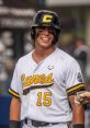 Bryan Arendt smiles during a baseball game, showcasing skills in his Canes uniform, number 15, with a confident stance.