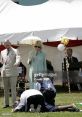 Camilla O'Donnell Morrison observes a children's activity with Prince Charles at a festive outdoor event.